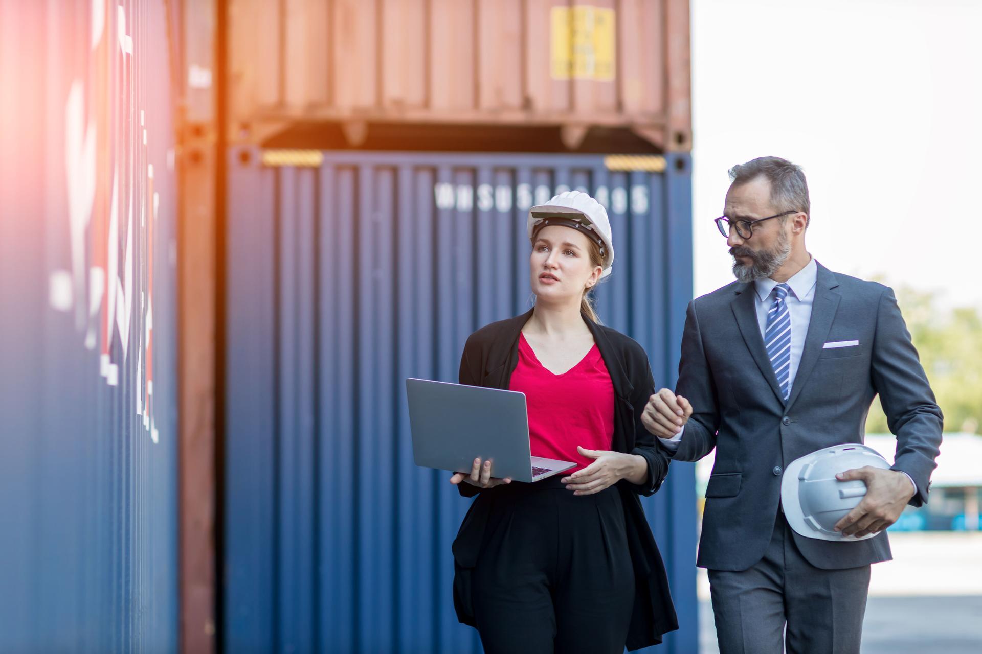 Businessman and Secretary work at Container cargo site check up goods in container. Manager and customer checking on shipping containers. Logistics and shipping.