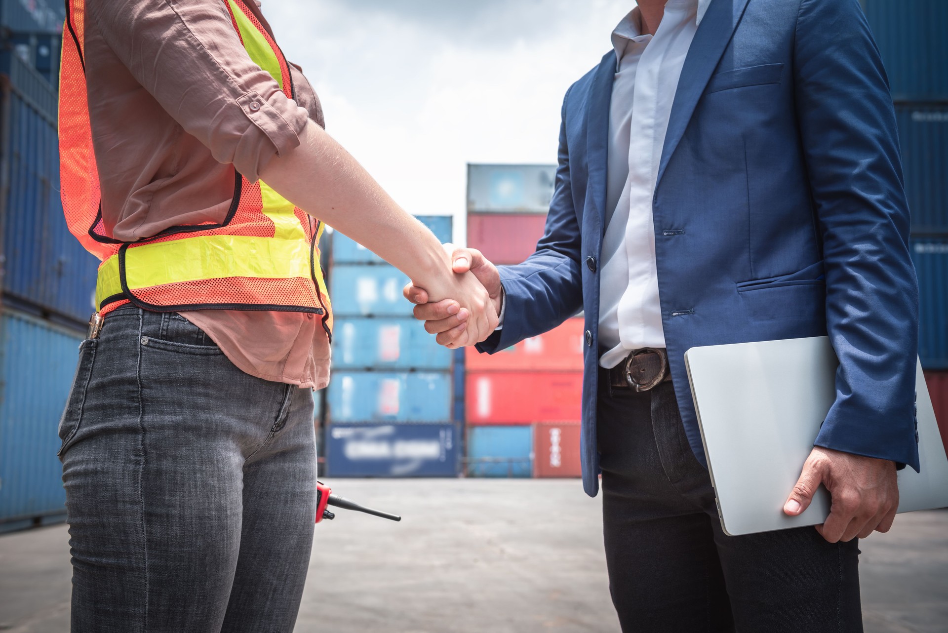 Businessman and Container Shipping Worker Handshake Together for Cooperation Shipment in Logistic Warehouse, Business Partnership Greeting Handshaking After Discussion Containers Transport Dealing.