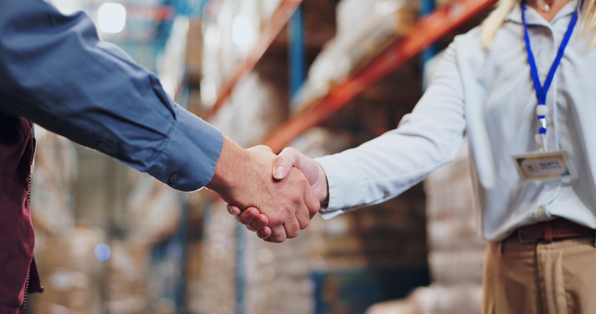 Handshake, agreement and teamwork for people in warehouse, meeting and deal for supply chain. Partnership, logistics and management shaking hands, distribution collaboration and courier company